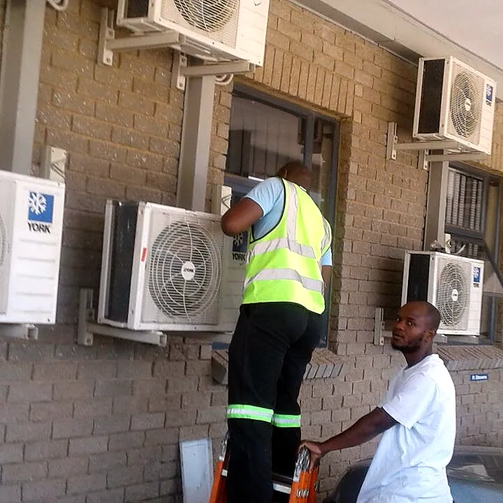 Mobile Fridge Repairs technicians installing an aircon unit on site